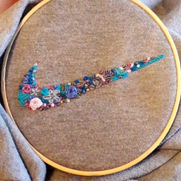Embroidery of a jumper with a flowery nike swoosh