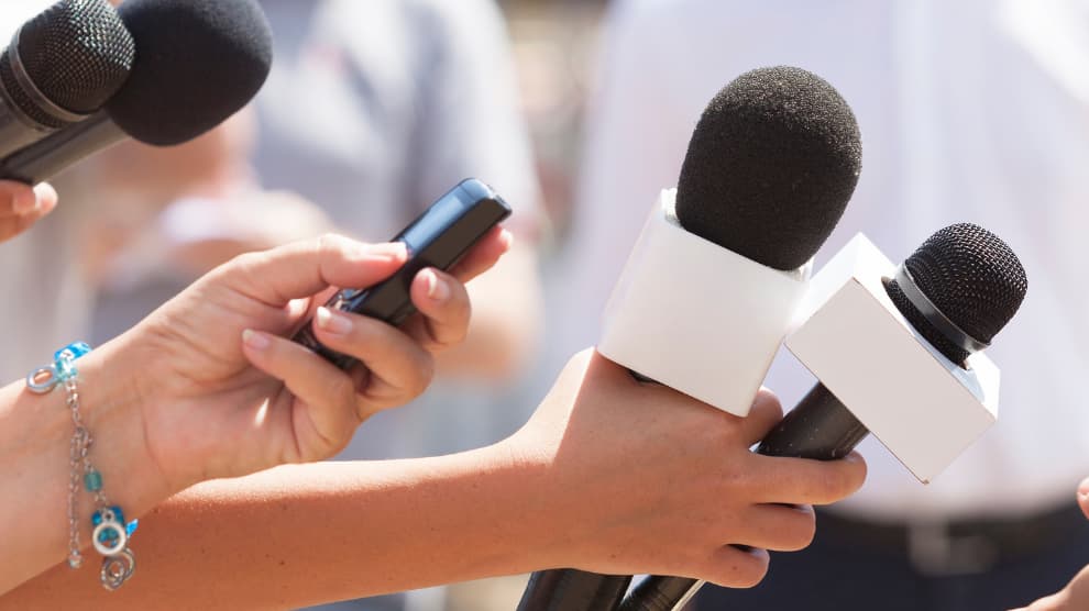 picture of reporters holding mics speaking about construction marketing strategy
